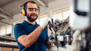A man with ear protection glasses operates industrial machinery in a workshop, showcasing the quick wins of having skilled personnel within a robust recruitment funnel.